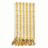 A cotton beach towel with large yellow stripes and a tassel fringe.