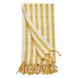 A cotton beach towel with large yellow stripes and a tassel fringe.