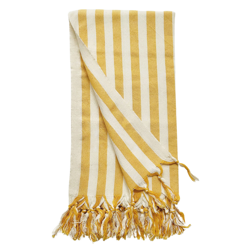 A cotton beach towel with large yellow stripes and a tassel fringe.