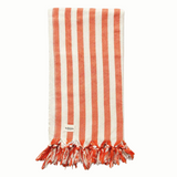 A cotton beach towel with large orange stripes and a tassel fringe.