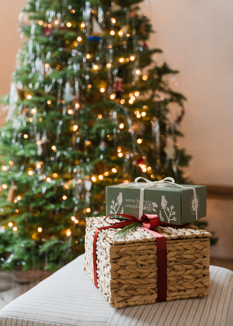 two Santa Barbara Company holiday gifts tied with ribbon and stacked
